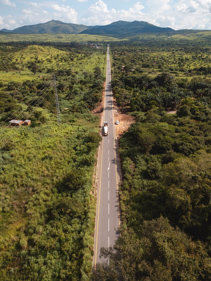 Aerial view of a road cutting through the lush green landscape of Dundo, Angola.