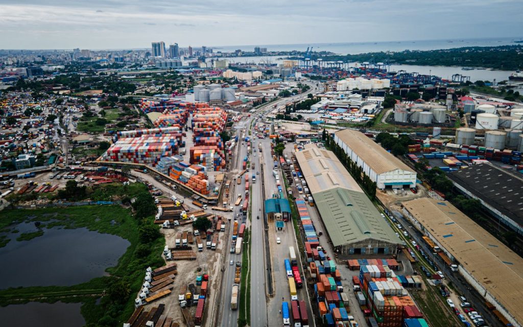 Aerial shot of bustling Dar es Salaam port with container yards and city skyline.